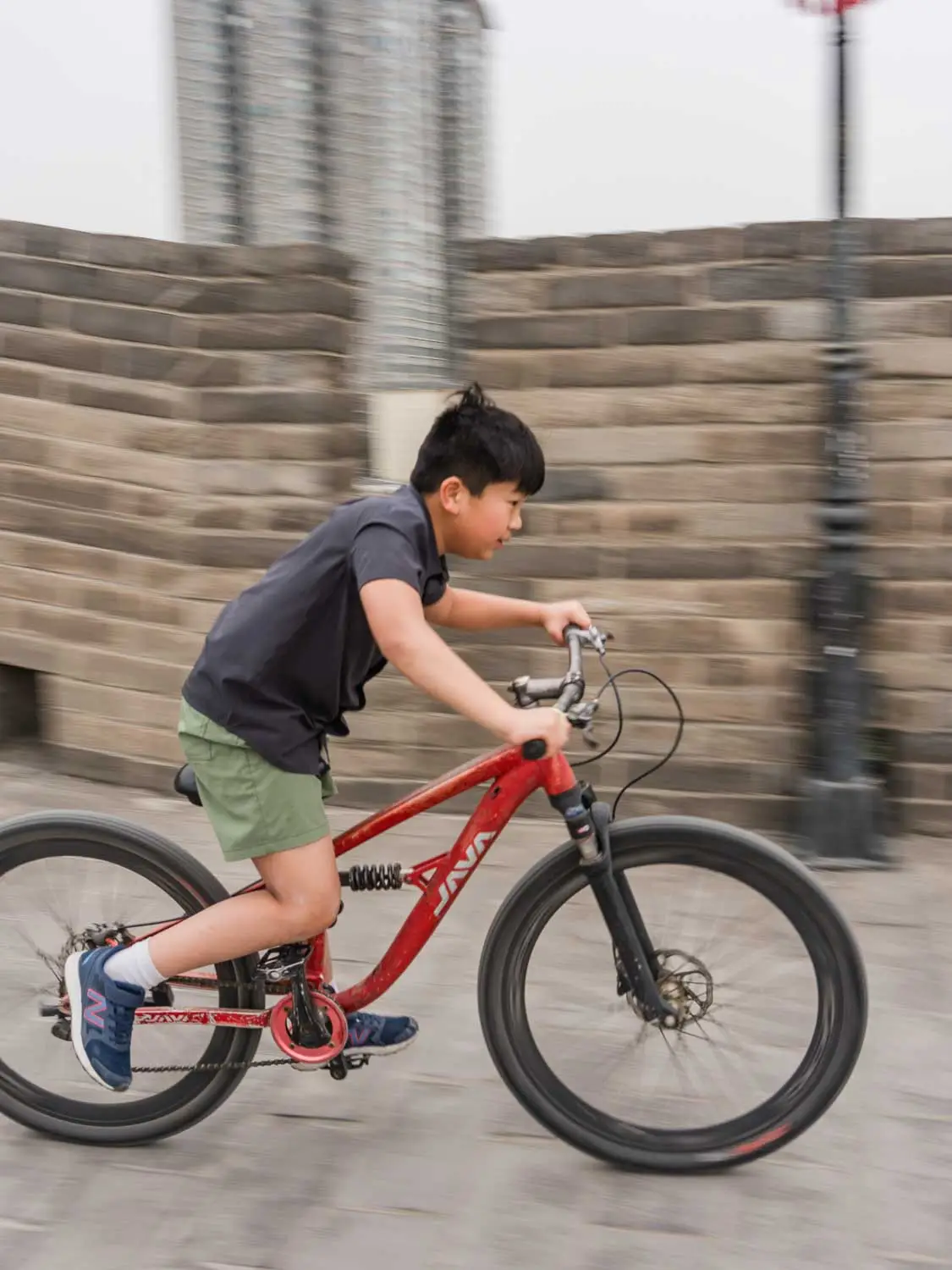 Child riding bike on city wall